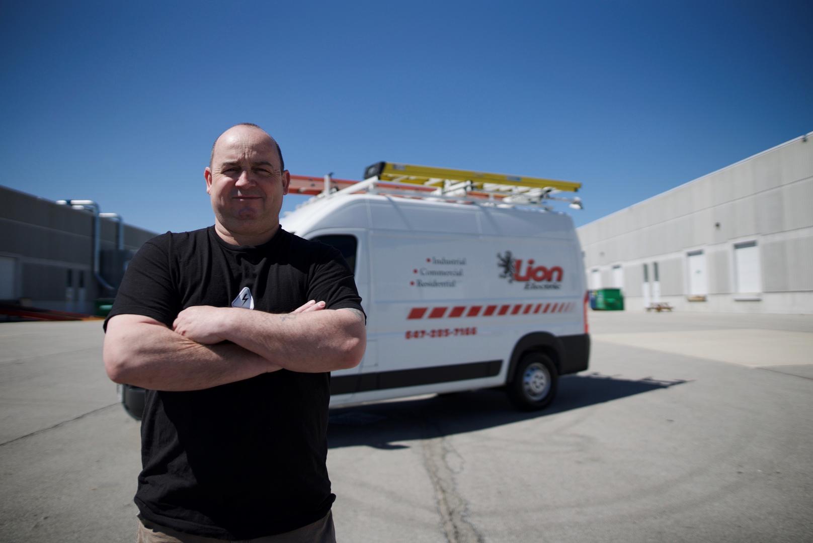 Lion Electric technician standing in front of branded service van